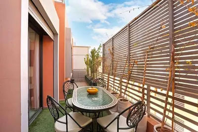 a patio with a table and chairs on a balcony at Elegant and Modern appart hôtel with Best location in Marrakech