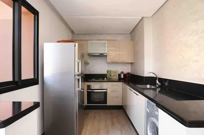 a kitchen with a stainless steel refrigerator in it at Elegant and Modern appart hôtel with Best location in Marrakech