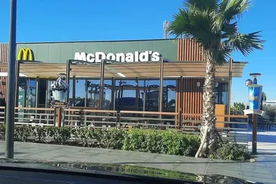 a mcdonalds restaurant with a palm tree in front of it at Appartement calme, proche de toutes commodités in Marrakech