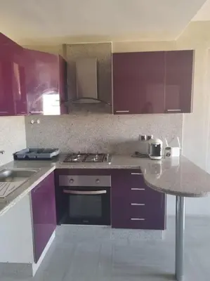 a kitchen with purple cabinets and a counter top at Appartement calme, proche de toutes commodités in Marrakech