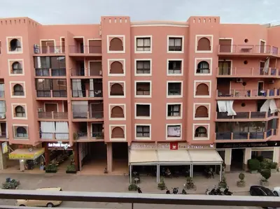 a large pink building with a lot of balconies at Appartement calme, proche de toutes commodités in Marrakech