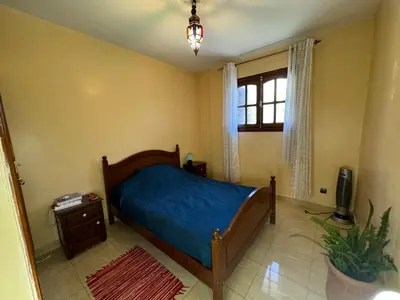 a bedroom with a bed with a blue sheets and a window at B and b in our house in Marrakech