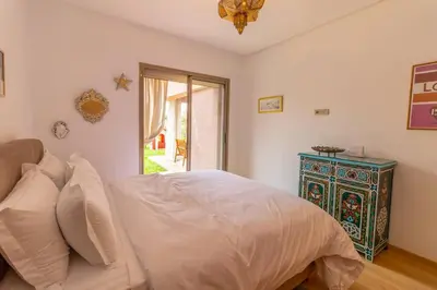 a bedroom with a white bed and a blue cabinet at Peaceful apartment with a garden in Marrakech