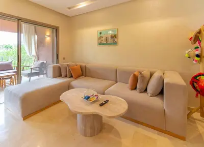a living room with a couch and a table at Peaceful apartment with a garden in Marrakech