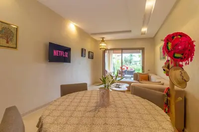 a dining room with a table and a living room at Peaceful apartment with a garden in Marrakech