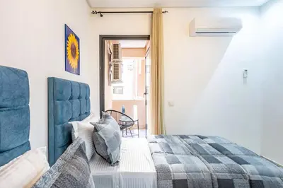 a bedroom with a bed with a blue head board at Appartement chic et moderne in Marrakech