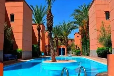a swimming pool with palm trees in a resort at riad ladana bienvenue au coeur de marrakech in Marrakech
