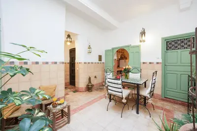 a dining room with green doors and a table and chairs at Riad Ghita Exclusif 15 min de Jemaa El Fnaa in Marrakech