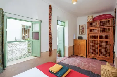 a living room with a large window and a table at Riad Ghita Exclusif 15 min de Jemaa El Fnaa in Marrakech