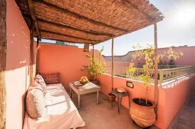 a balcony of a house with a table and a bed at Riad Ghita Exclusif 15 min de Jemaa El Fnaa in Marrakech