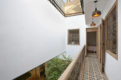 a hallway of a house with white walls and a staircase at Riad Ouladi -Exclusif - 5mn Jemaa El Fnaa -Pool in Marrakech