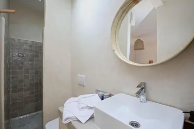 a bathroom with a white sink and a mirror at Riad Ouladi -Exclusif - 5mn Jemaa El Fnaa -Pool in Marrakech