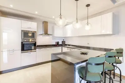 a kitchen with white cabinets and a table and chairs at Appartement au cœur de Marrakech in Marrakech
