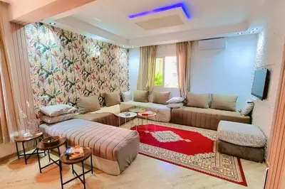 a living room with a couch and a tv at Spacieux Studio by Nina in Marrakech