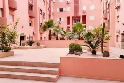 a courtyard in a building with pink buildings at Spacieux Studio by Nina in Marrakech