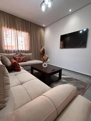 a living room with a couch and a flat screen tv at Appartement familiale top one saada in Marrakech