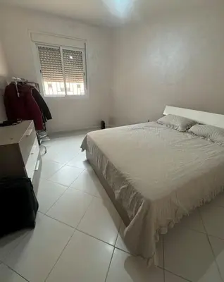 a white bedroom with a bed and a window at EuroOriental house in Marrakech