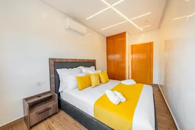 a bedroom with a large bed with yellow pillows at VISTA HOLIDAYS ctm in Marrakech