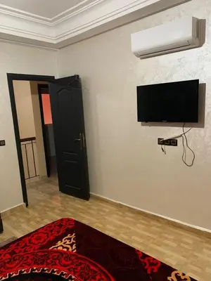 a room with a flat screen tv on a wall at Résidence Sakan Ennakhil in Marrakech