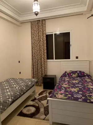 a bedroom with a bed and a window at Résidence Sakan Ennakhil in Marrakech