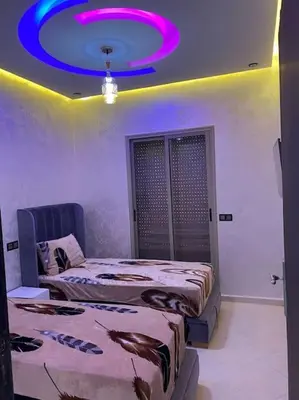 a room with two beds and a purple ceiling at Cosy et Agréable Appartement in Marrakech