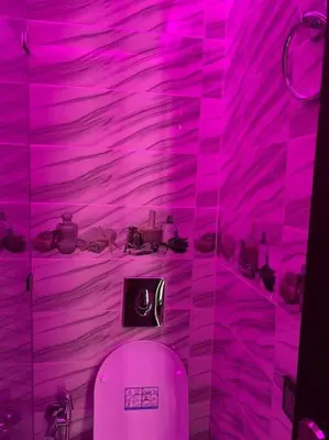 a pink bathroom with a toilet and a purple wall at Cosy et Agréable Appartement in Marrakech