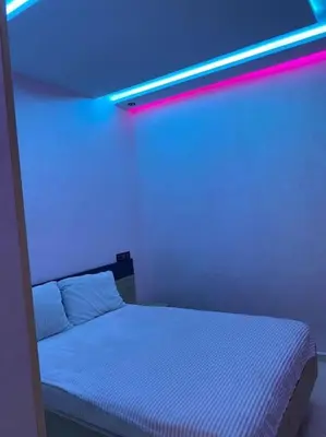 a bedroom with a white bed with a blue light at Cosy et Agréable Appartement in Marrakech