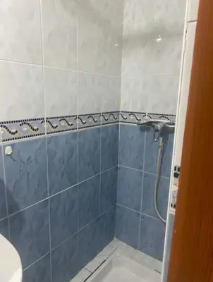 a bathroom with a shower with blue and white tiles at Riyad piscine intérieure privative in Marrakech