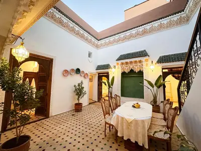 a dining room with a table and chairs and a chalkboard at Riad M Azbetz in Marrakech