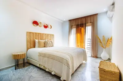 a white bedroom with a bed and a window at Bohemian Style in hyper-center - Wifi in Marrakech