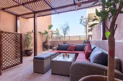 a patio with a couch and a table at Sumptuous appart Heart of Hivernage - Pool in Marrakech