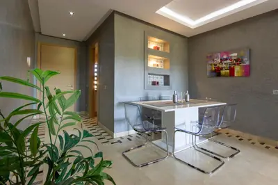 a kitchen with a table and chairs and a plant at Relaxation et Confort a Prestigia -10 min du centre in Marrakech