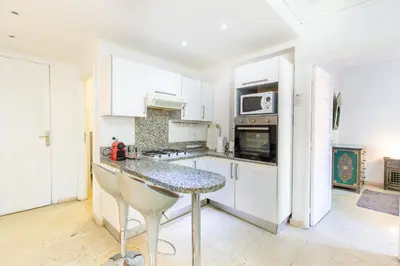 a kitchen with white cabinets and a granite counter top at Romantic Retreat next to M avenue in Marrakech