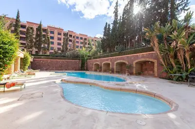 a swimming pool in a courtyard with a building at Romantic Retreat next to M avenue in Marrakech