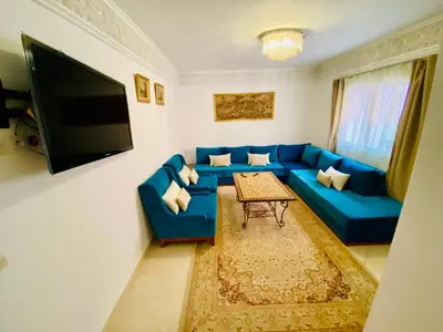 a living room with a blue couch and a table at Appart Moderne Calme & Climatisé in Marrakech