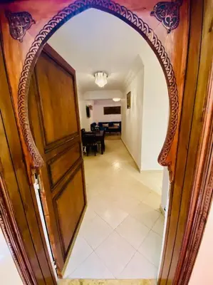 a hallway with an arched door and a living room at Appart Moderne Calme & Climatisé in Marrakech