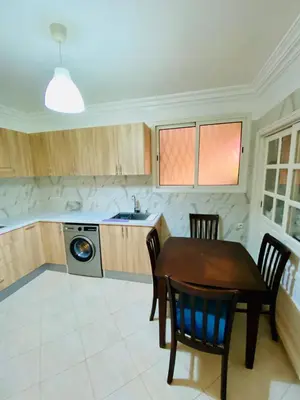 a kitchen with a table and chairs and a sink at Appart Moderne Calme & Climatisé in Marrakech