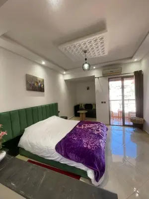 a bedroom with a bed with a purple blanket at Un agréable studio in Marrakech