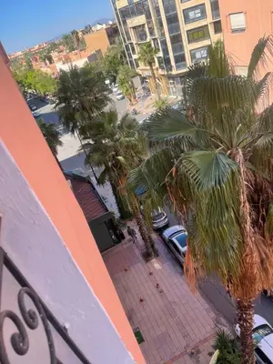a view of a street with palm trees and buildings at Un agréable studio in Marrakech