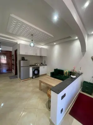 a living room with a green couch and a table at Un agréable studio in Marrakech
