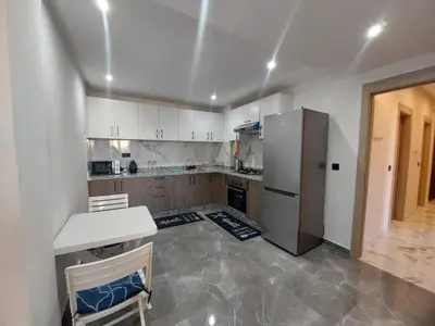a kitchen with white cabinets and a refrigerator at Palm Appart in Marrakech