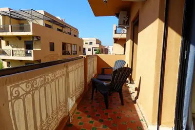 a chair sitting on the balcony of a building at Cozy & Chic Appart Haut Standing Résidence Piscine in Marrakech
