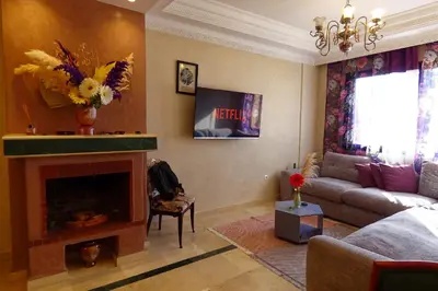 a living room with a couch and a fireplace at Cozy & Chic Appart Haut Standing Résidence Piscine in Marrakech