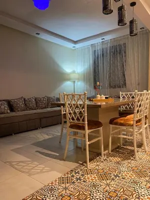a living room with a table and chairs and a couch at appartement in Marrakech