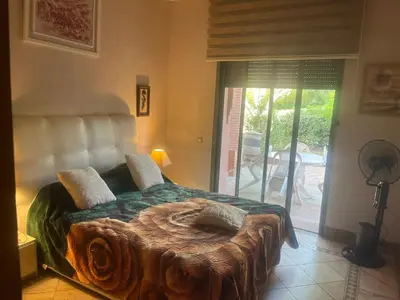 a bedroom with a large bed and a sliding glass door at Marrakech 2 in Marrakech