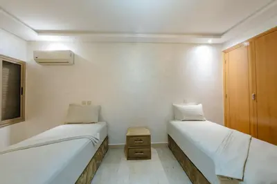 a room with two beds and a night stand in it at Charming City Getaway in Marrakech