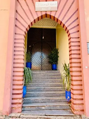 an archway with stairs and potted plants in front of a building at Appart Moderne Calme & Climatisé in Marrakech