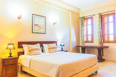a bedroom with a bed and two lamps and windows at Villa 36 Amelkis - Pool & Garden in Marrakech