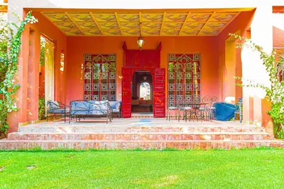 an orange house with chairs on the stairs at Villa 36 Amelkis - Pool & Garden in Marrakech