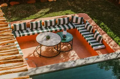 an overhead view of a table and chairs next to a pool at Villa - Piscine chauffée sur demande et gouvernante in Marrakech